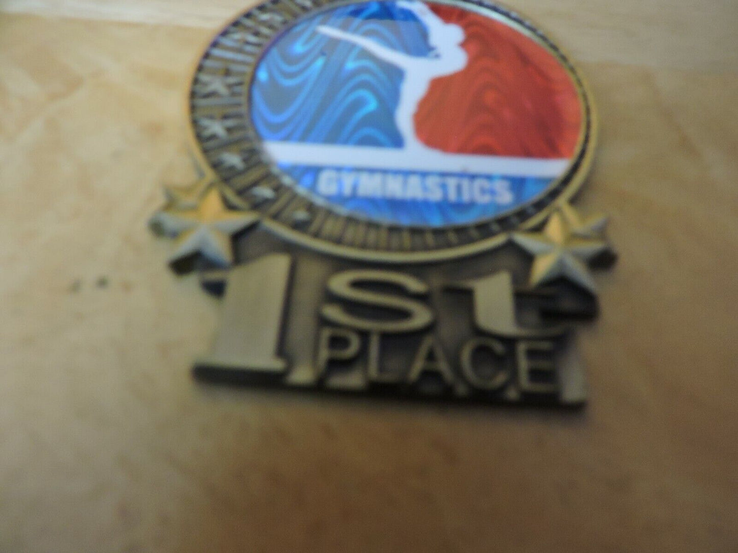 GYMNASTIC GOLD  COLORED 2.5 X 3.5 INCH MEDAL WITH BLUE RIBBON 1ST PLACE