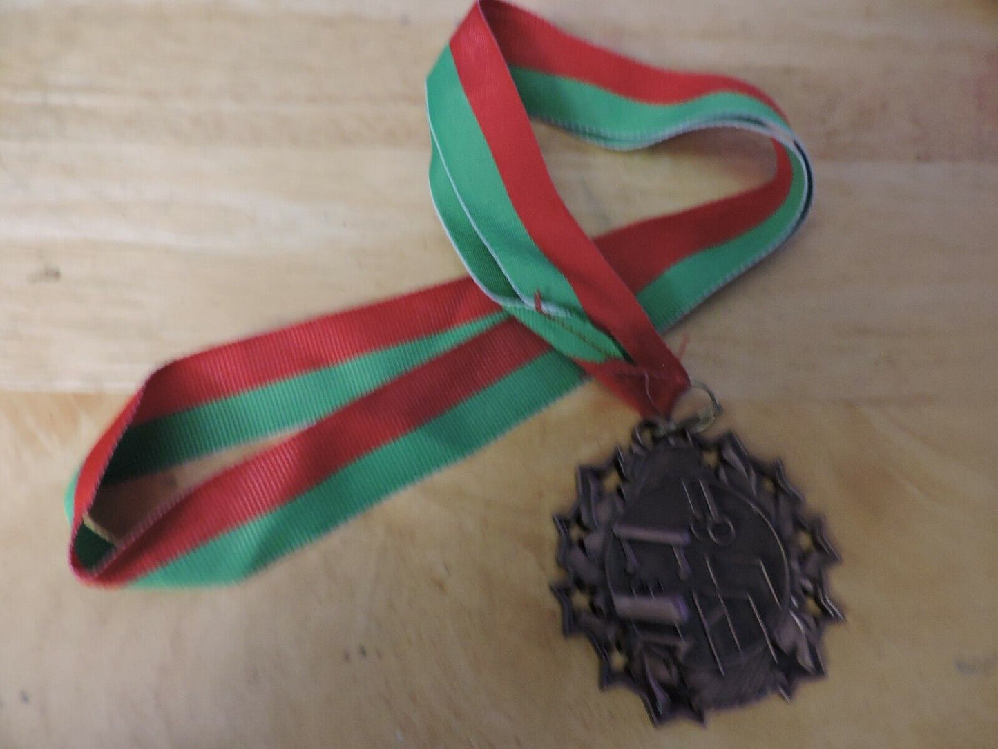 GYMNASTIC GOLD COLORED 2.5 INCH ROUND MEDAL WITH RED AND GREEN RIBBON