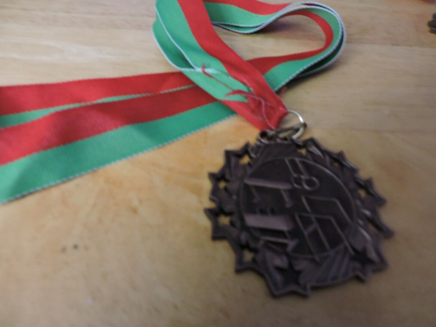 GYMNASTIC GOLD COLORED 2.5 INCH ROUND MEDAL WITH RED AND GREEN RIBBON