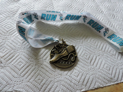 RUNNING MEDAL--2.25 X 2 INCHES WHITE RIBBON WITH BLUE LETTERING