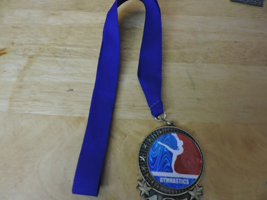GYMNASTIC GOLD  COLORED 2.5 X 3.5 INCH MEDAL WITH BLUE RIBBON 1ST PLACE