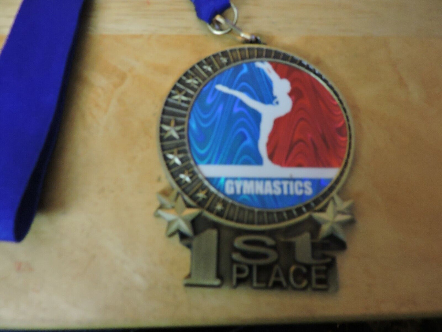 GYMNASTIC GOLD  COLORED 2.5 X 3.5 INCH MEDAL WITH BLUE RIBBON 1ST PLACE
