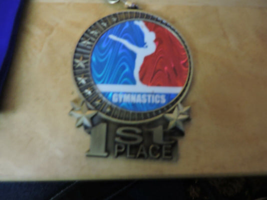 GYMNASTIC GOLD  COLORED 2.5 X 3.5 INCH MEDAL WITH BLUE RIBBON 1ST PLACE