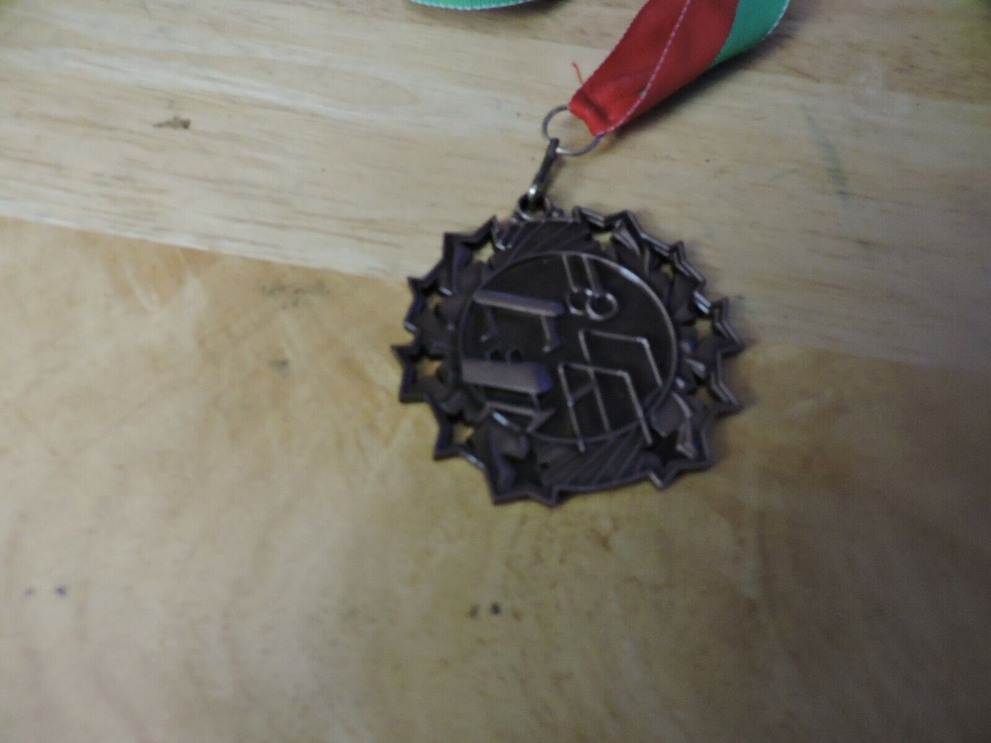 GYMNASTIC GOLD COLORED 2.5 INCH ROUND MEDAL WITH RED AND GREEN RIBBON