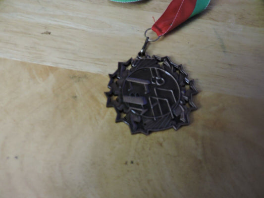 GYMNASTIC GOLD COLORED 2.5 INCH ROUND MEDAL WITH RED AND GREEN RIBBON